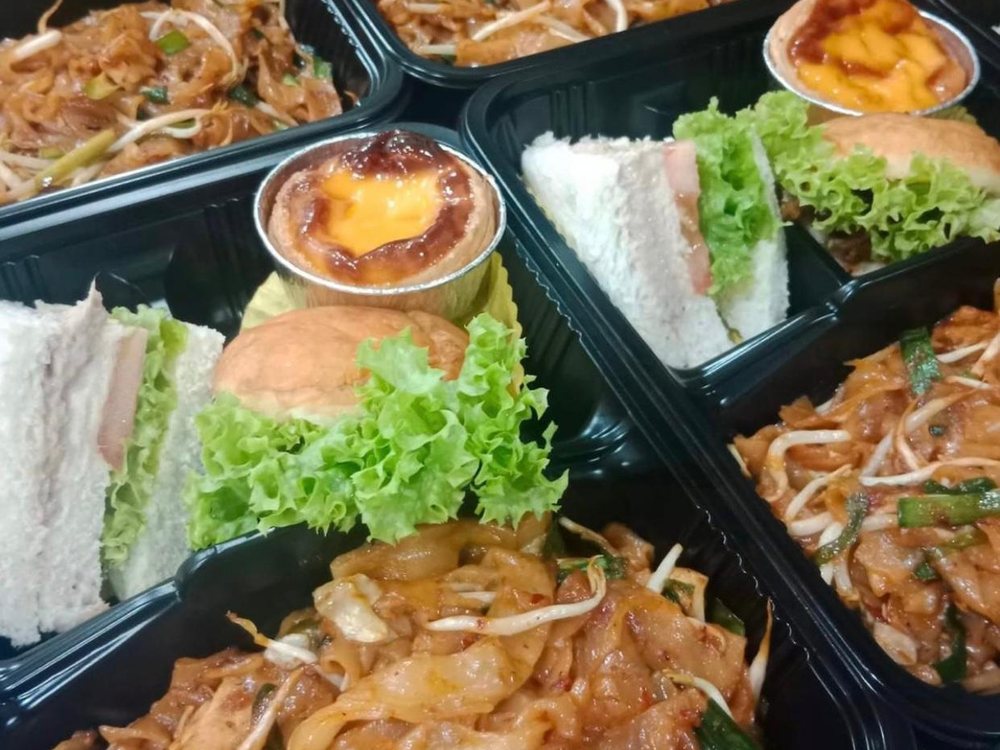 Bento sets with fried kway teow, sandwich, bun and egg tart