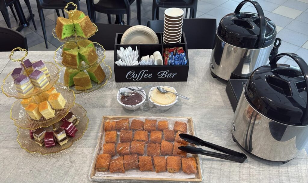 Coffee bar with pandan chiffon cake, layered petit cakes and a tray of pastries for a staff event