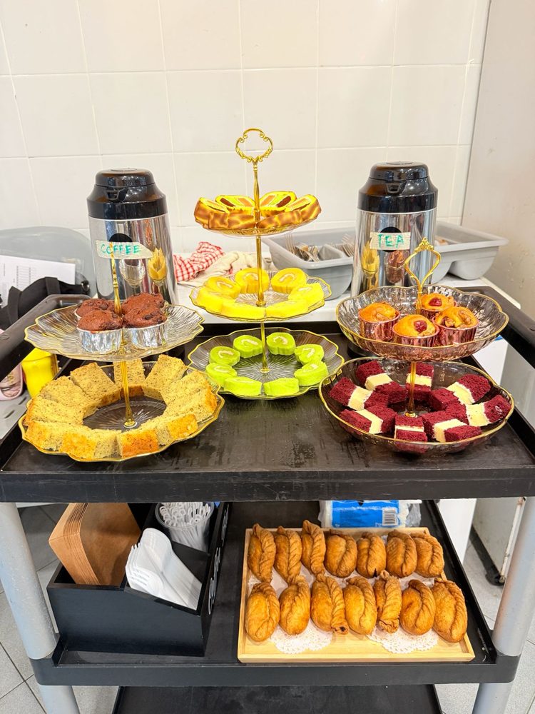 Tea break spread with cakes, swiss rolls, muffins, curry puffs, coffee and tea