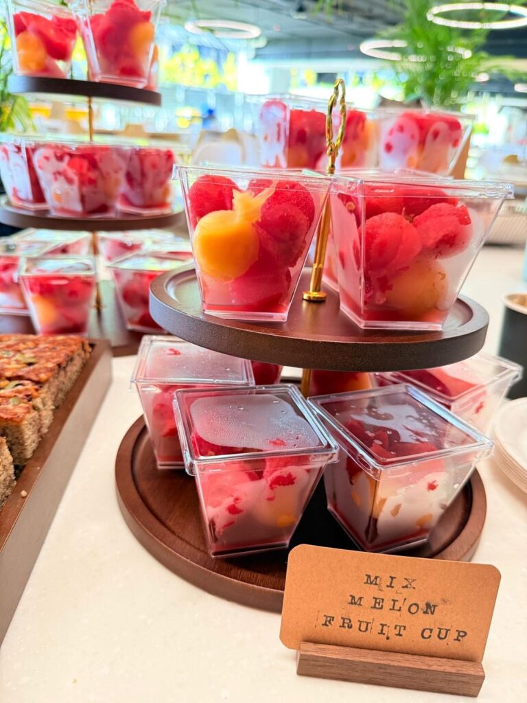 Mixed melon fruit cups on a wooden stand for a staff tea break