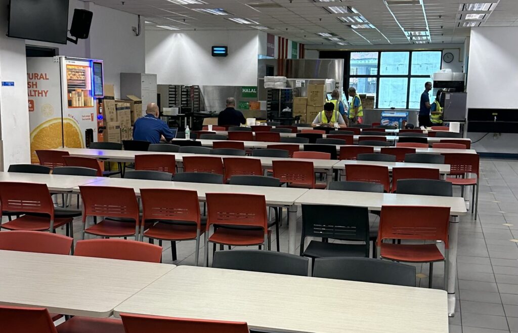 Staff canteen dining hall managed by Catering Corner in Singapore, with food counters at the back