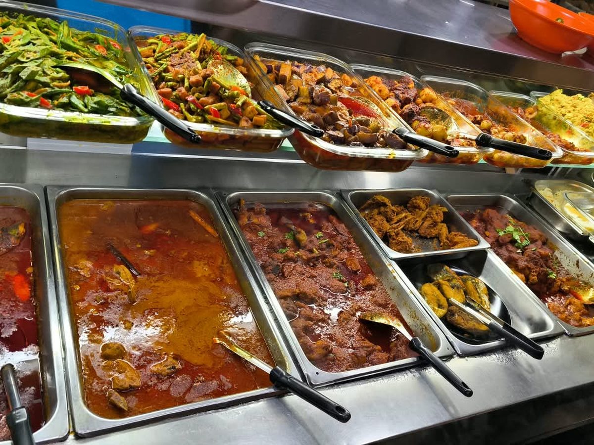 Nasi padang line at a Catering Corner staff canteen in Singapore, with curries, vegetables and fried fish