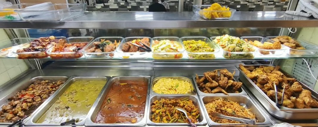 Economic rice line at a staff cafeteria with curries, fried rice, fried bee hoon and fried chicken