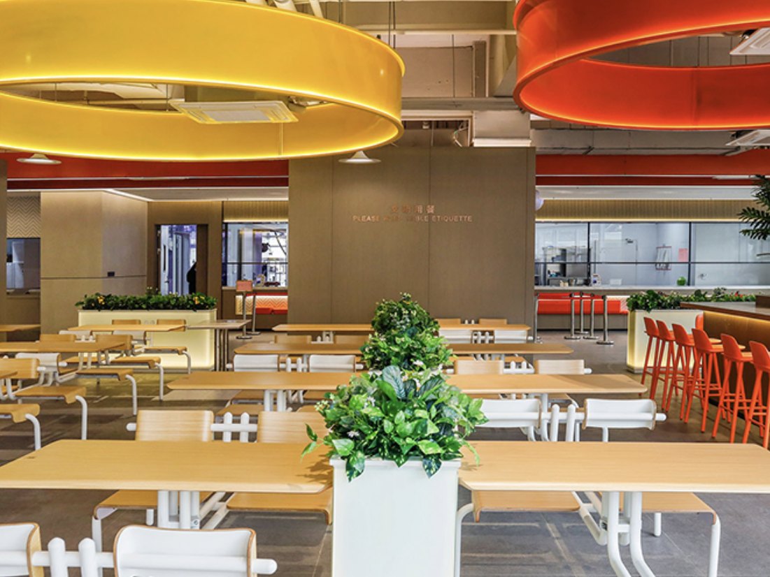 Modern staff cafeteria dining area with communal tables and bar seating
