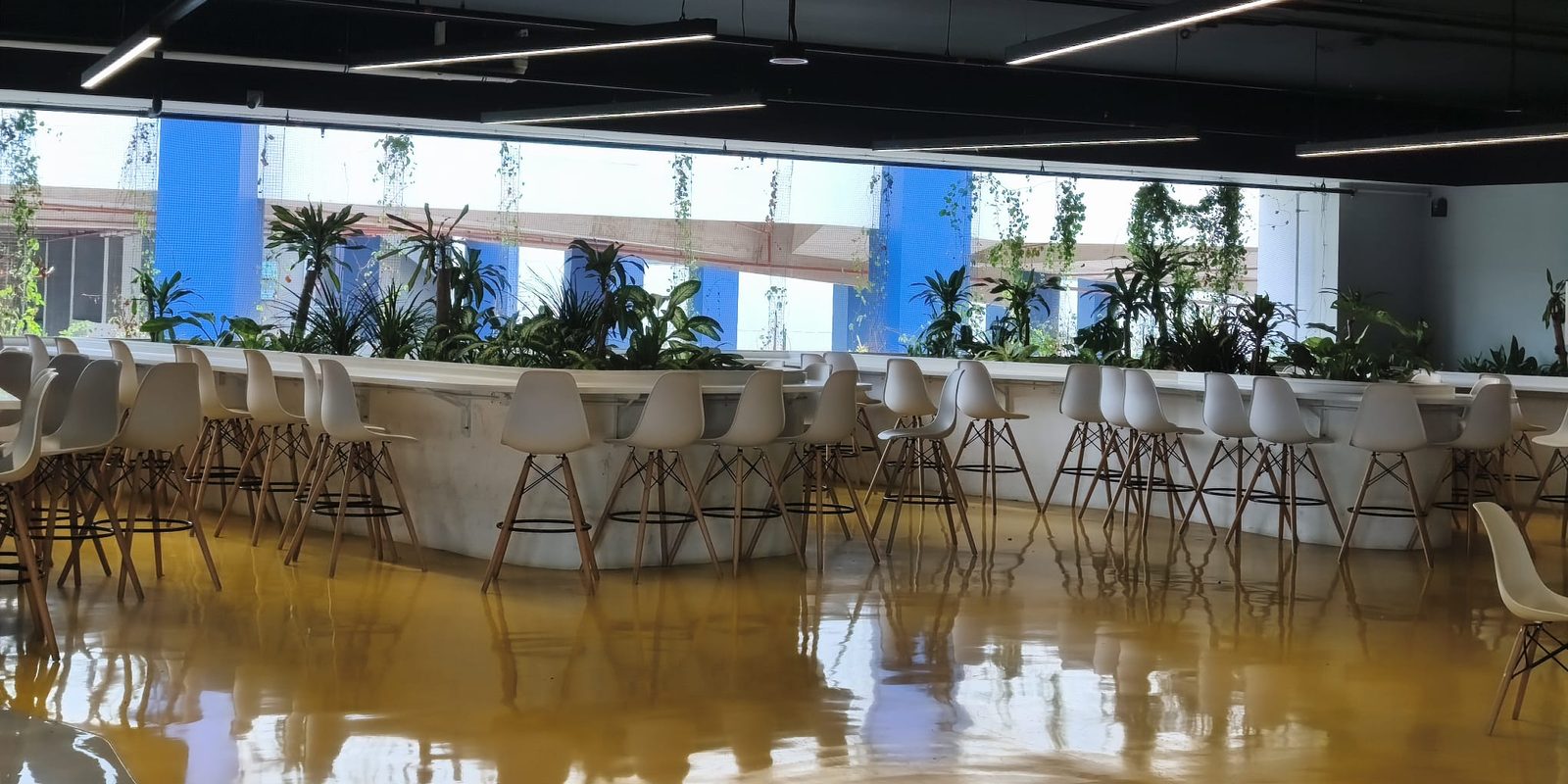 Staff canteen dining hall with bar-height seating along planter counters, run by Catering Corner in Singapore