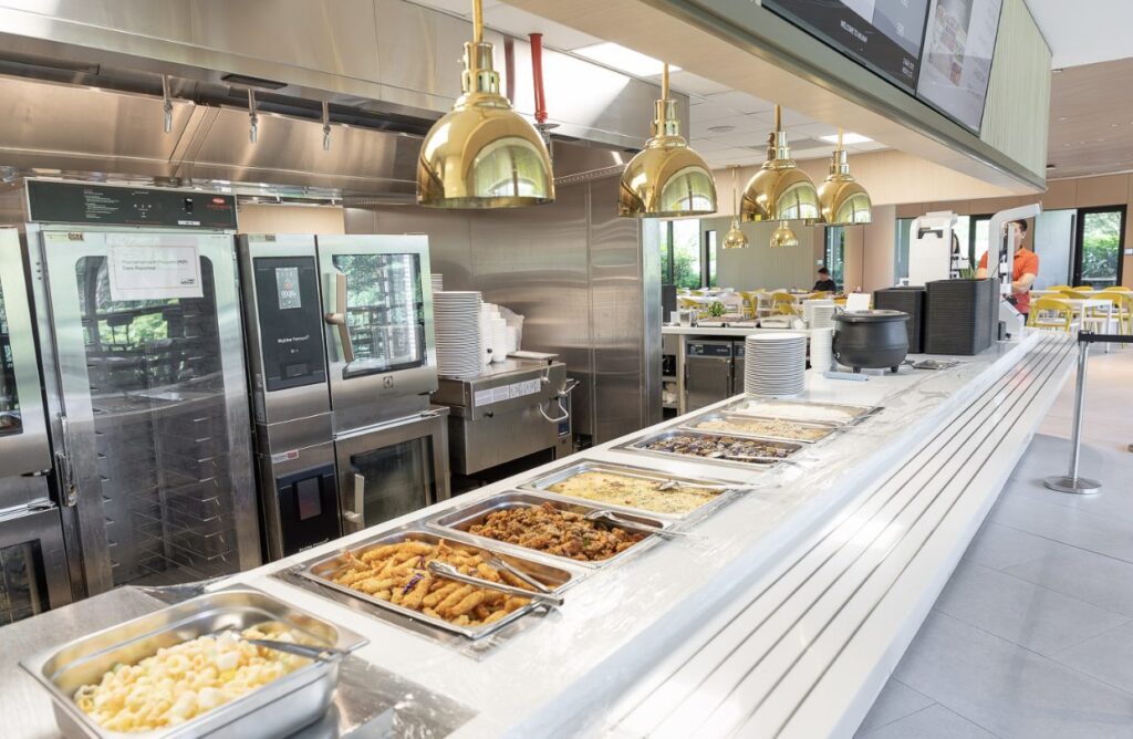 Hot food servery with heat lamps and combi ovens in an on-site staff canteen kitchen run by Catering Corner